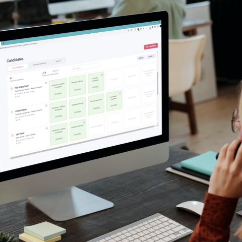 Computer on desk with person on phone